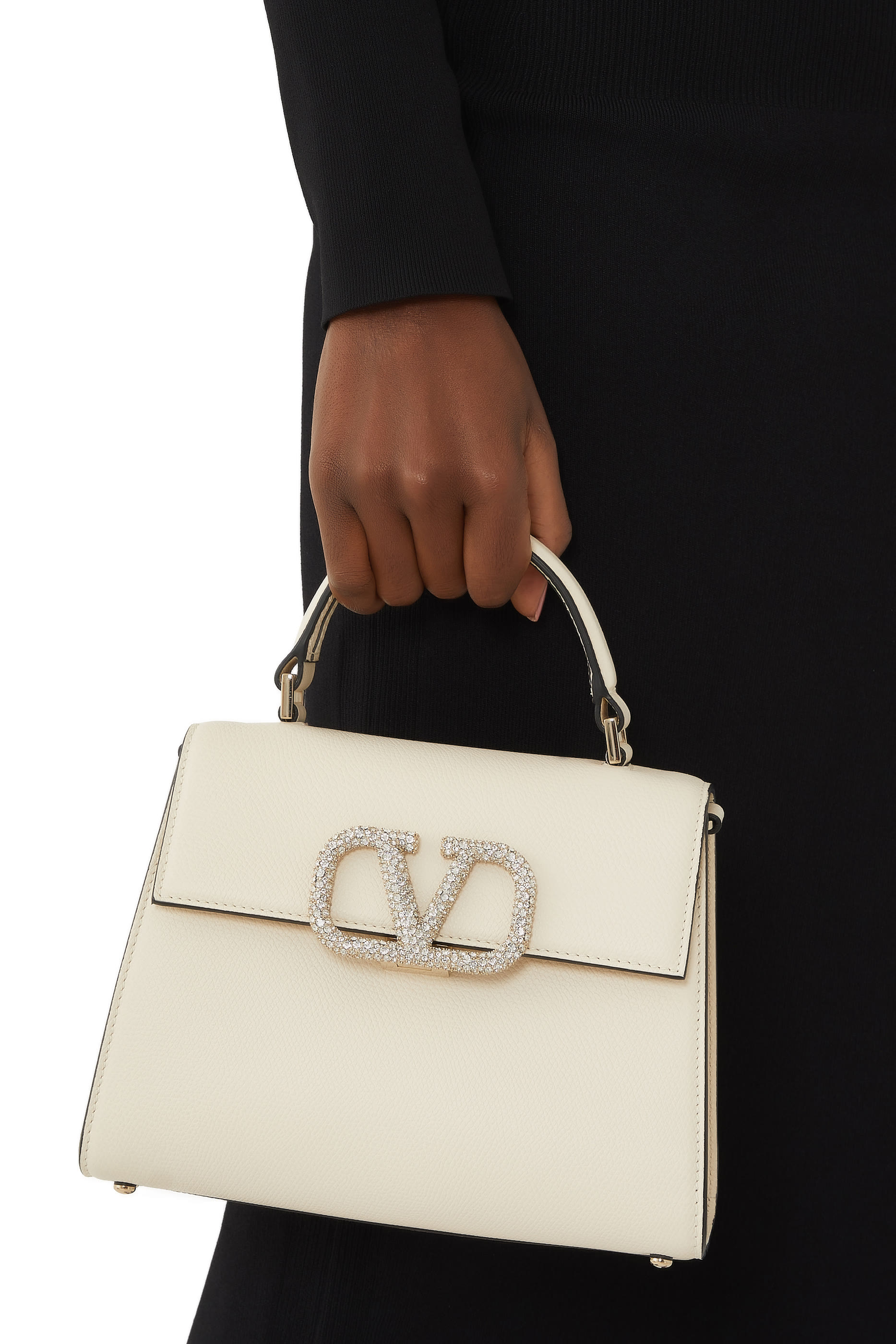 حقيبة صغيرة بيد علوية وشعار الماركة