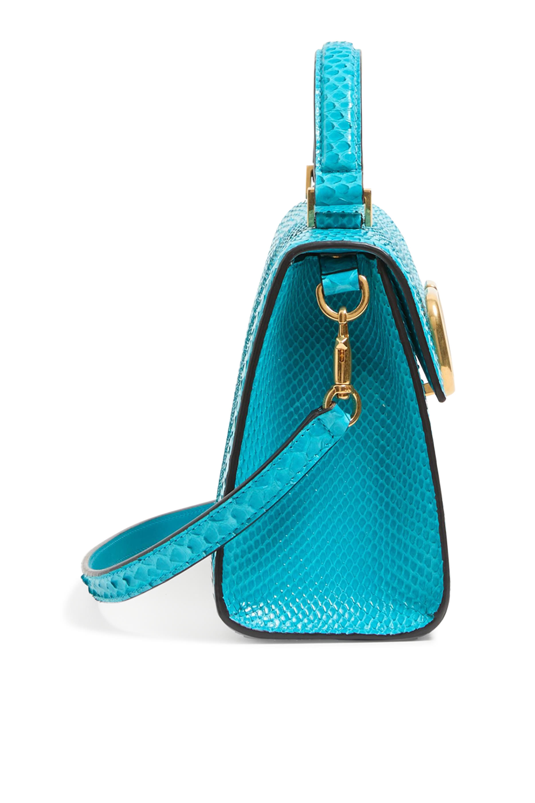 حقيبة صغيرة بيد علوية وشعار حرف الماركة