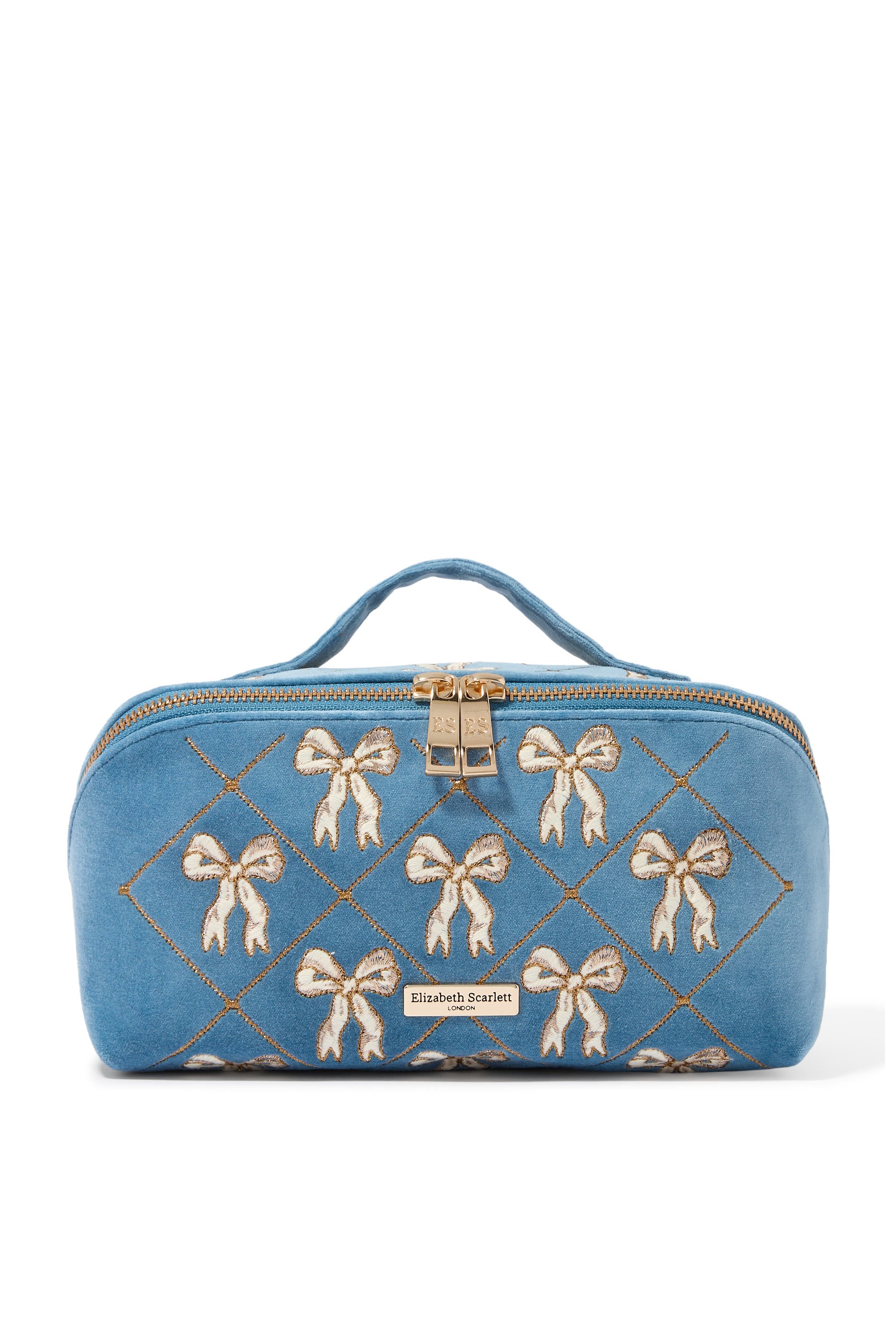 حقيبة مستحضرات التجميل مفتوحة ومسطحة مزينة بفيونكات مخمل