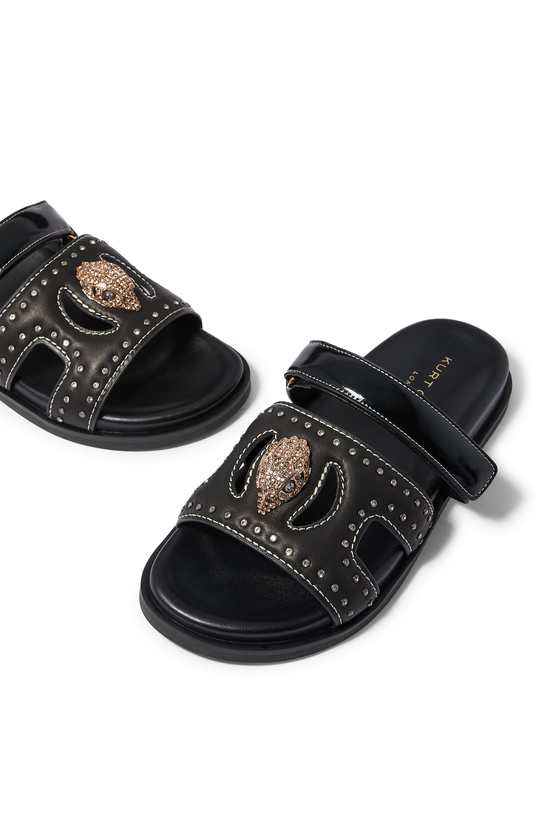 صندل بفتحات مزين بحلية بشعار الماركة 