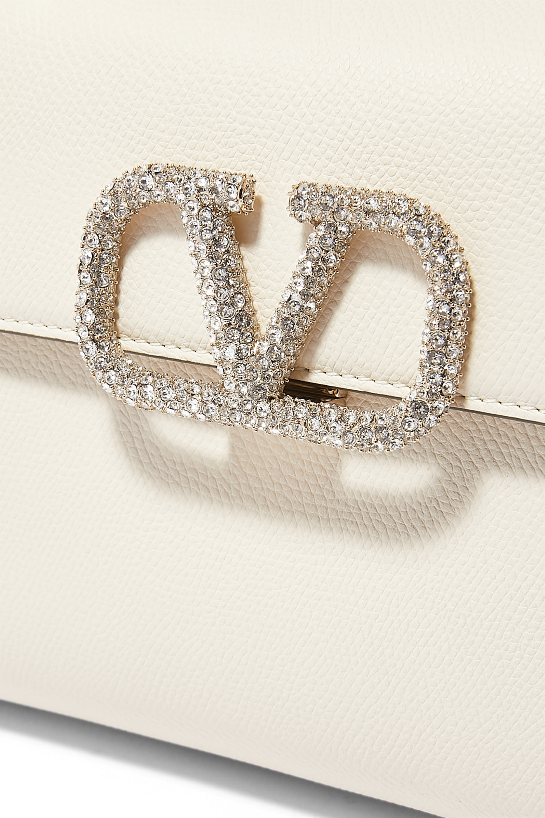 حقيبة صغيرة بيد علوية وشعار الماركة