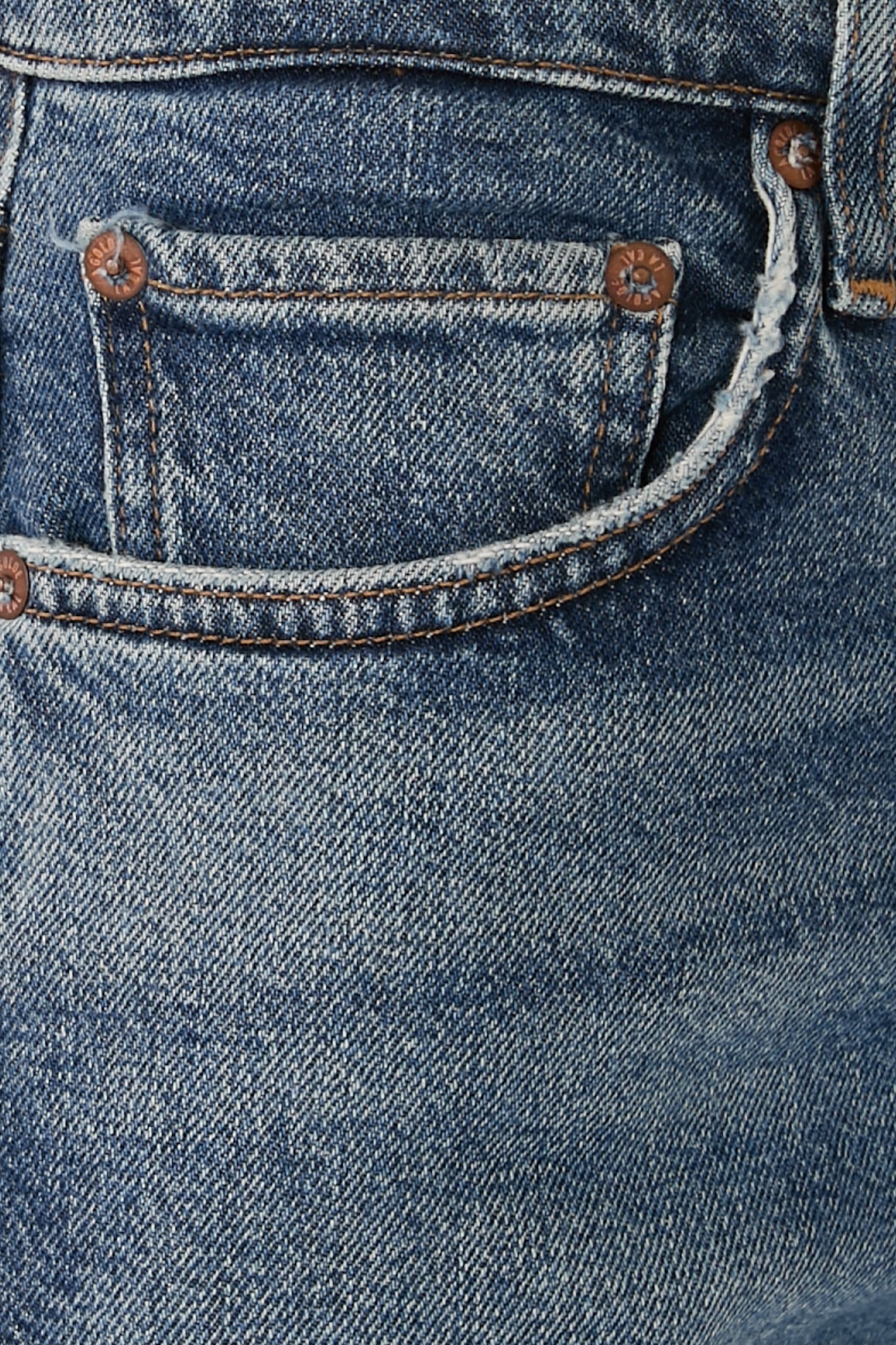 بنطال جينز بقصة مستقيمة بخصر مرتفع وخصر ضيق، مستوحى من التسعينيات.