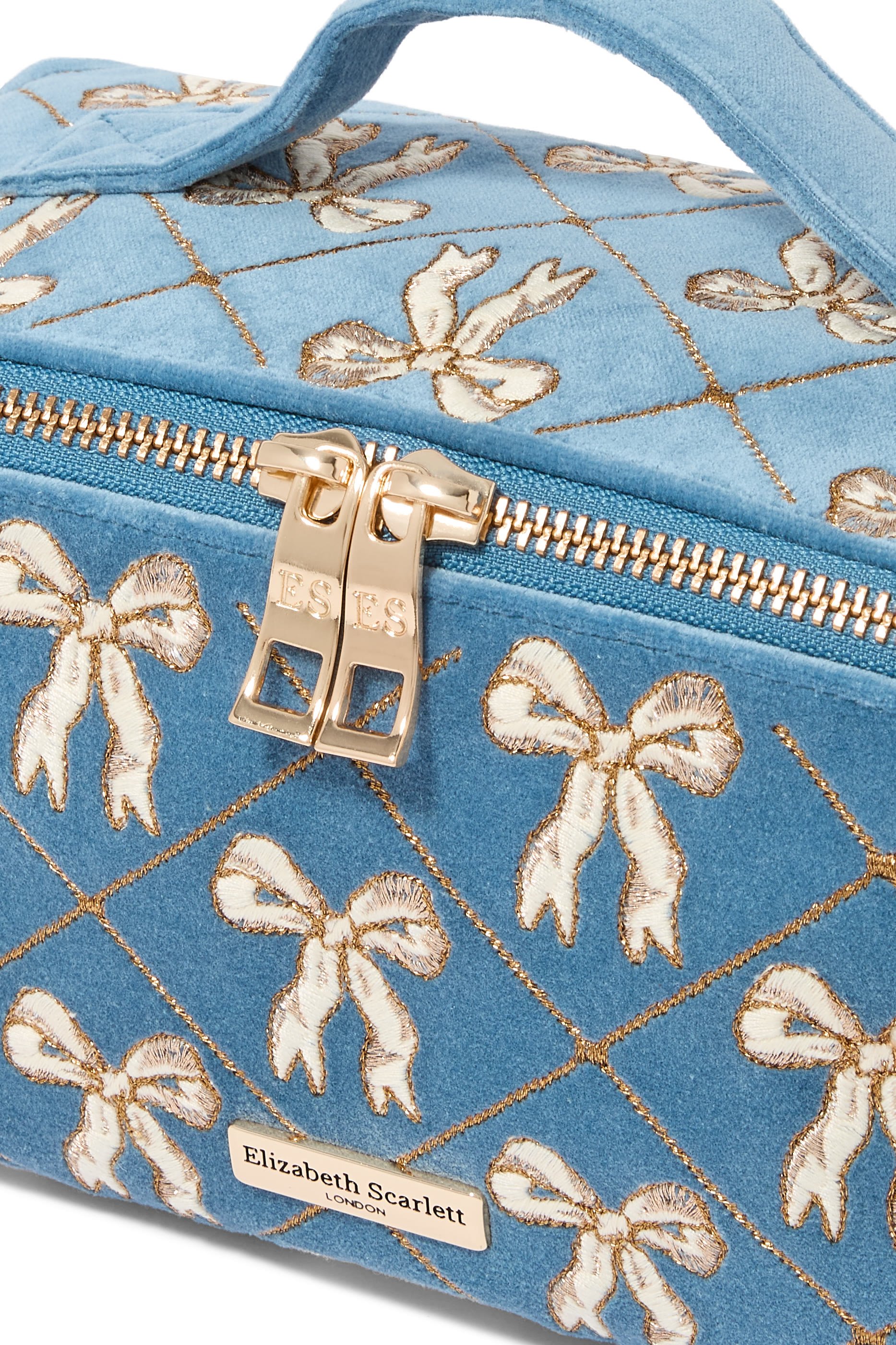 حقيبة مستحضرات التجميل مفتوحة ومسطحة مزينة بفيونكات مخمل