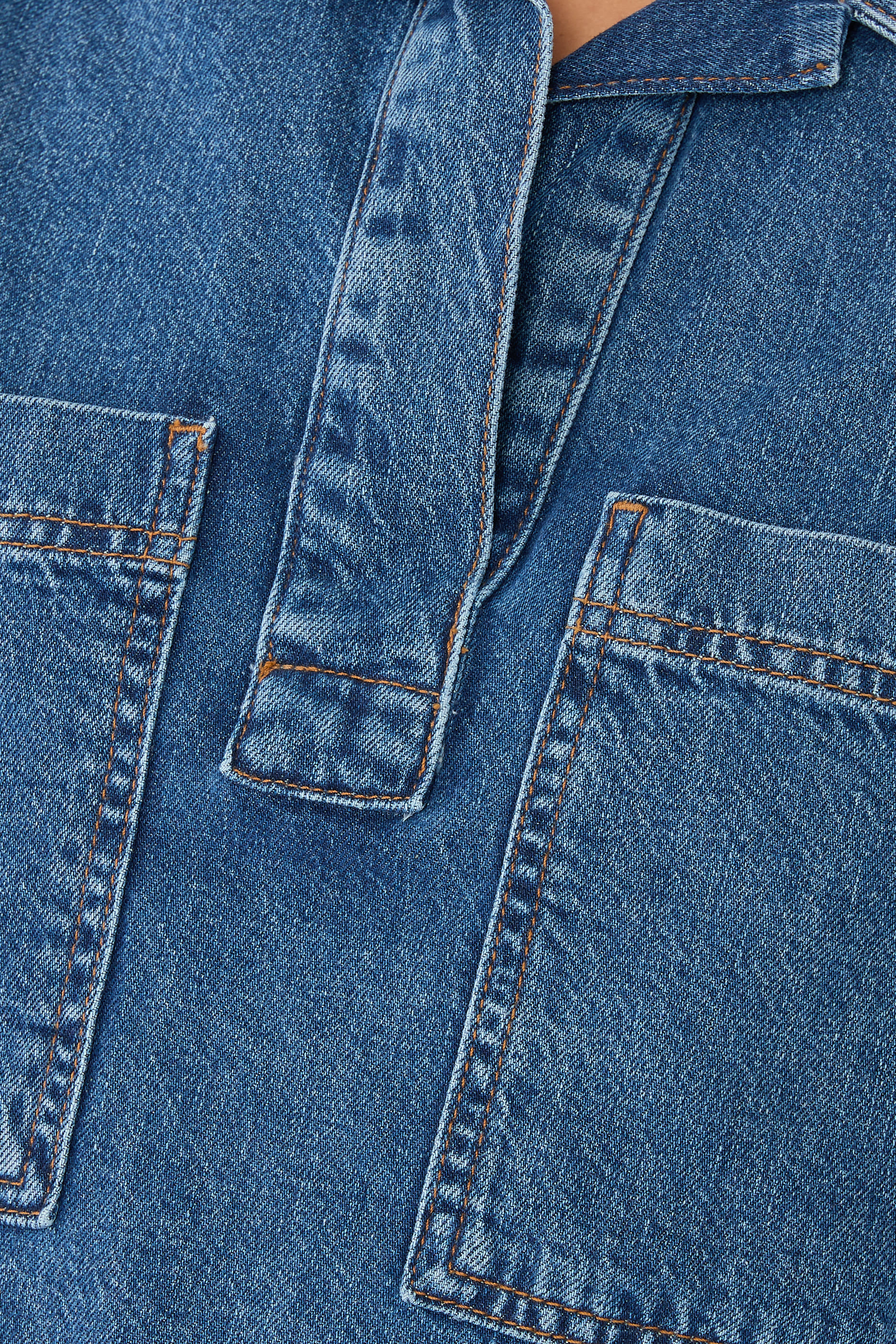 قميص دنيم بأكمام قصيرة وحافة قصيرة من الأمام وطويلة من الخلف